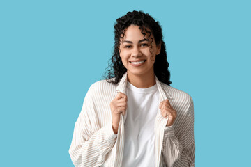 Poster - Beautiful young African-American woman in stylish striped collar shirt on blue background