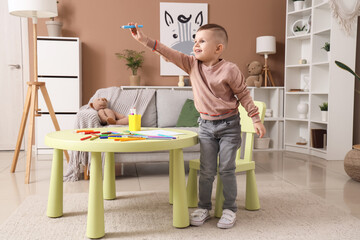 Wall Mural - Cute little boy with felt-tip pen drawing at home