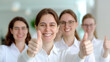 © TH_Stock - A group of cheerful, professional women give thumbs up in a bright, modern office environment. They show positivity, teamwork, and satisfaction with their success.