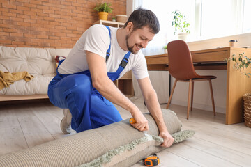 Wall Mural - Male loader cutting duct tape on rolled carpet in room