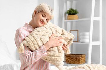 Poster - Young woman with short hair hugging pillow in bedroom