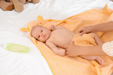 Sticker - Beautiful young mother with cute little baby and bottle of shampoo after bathing in bedroom at home