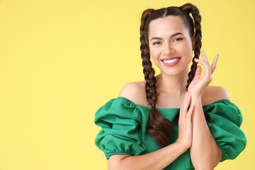 Wall Mural - Beautiful young happy stylish woman with braids on yellow background