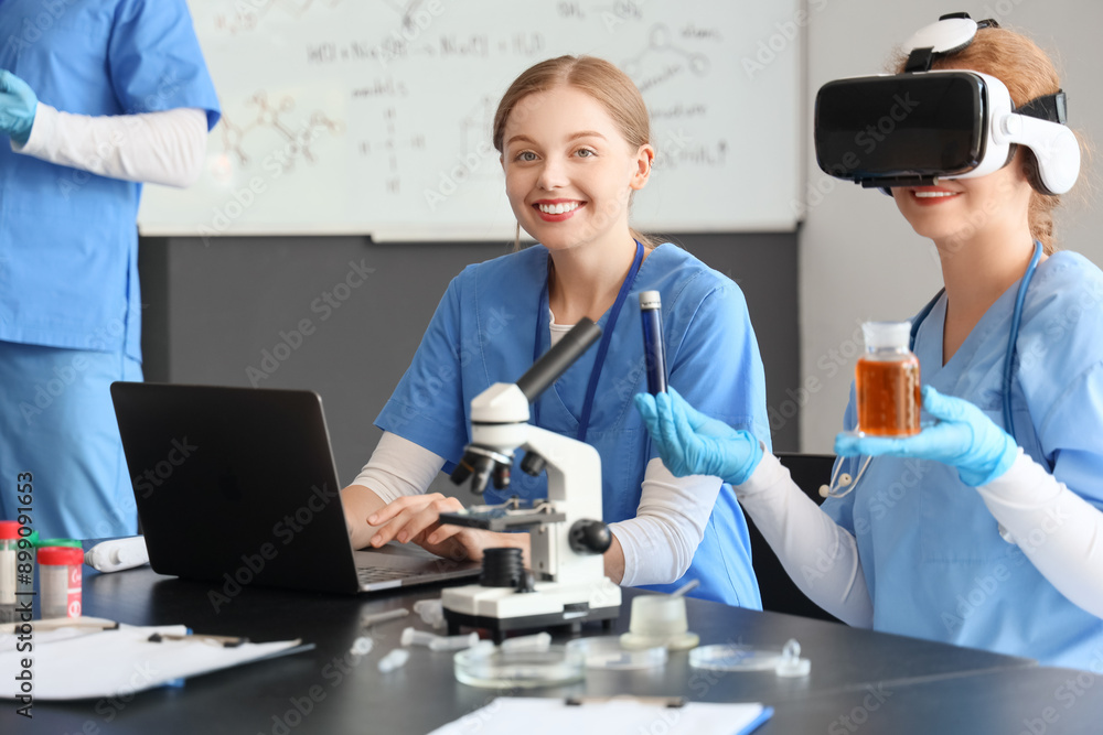 Female doctors with laptop using VR glasses in laboratory