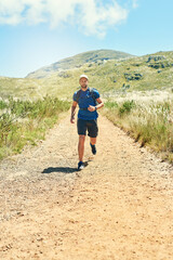 Wall Mural - Nature, running and man on path in mountain for fitness, marathon training and outdoor exercise. Trail, energy and healthy runner on hill in park with cardio, blue sky and morning workout challenge