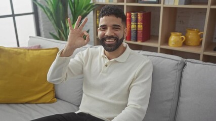 Poster - Young, smiling hispanic man at home, successfully doing an ok sign with hand and fingers showing positive expression