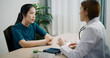 © Johnstocker - Selective focus, Asian doctor explains health problem of young female patient in clinic office, Health and medicine consultant, conversation about healthcare