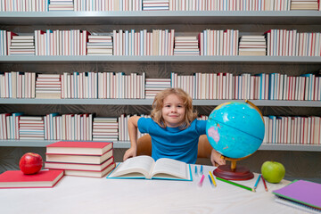 Fototapete - School and students in classroom. Education kids. Child pupil student in the school class. Studying and learning concept. School boy in the library near school supplies. Kid learn geography with globe