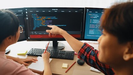Slow motion back end software developer engineer for computer programming working together on debugging writing computing code, solving complex algorithms display on monitor in office. Burgeoning