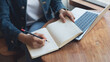 © tippapatt - 2025 Event planner timetable agenda plan on schedule event. Business woman checking weekly planner, taking note on calendar notebook on office table. Calendar event plan, work planning
