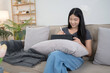© snowing12 - Young asian women reading business report about marketing and finance data of project and taking notes in tablet while sitting on couch to spending time and relaxation with enjoying lifestyle at home