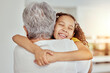 © Maass/peopleimages.com - Grandmother, girl and hug for love in home, affection and bonding or care in apartment living room. Family, grandchild and grandma on couch and happy on weekend, comfort and smile in house lounge