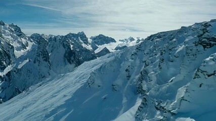 Poster - A mountain range covered in snow with a clear blue sky in the background. The snow is piled up on the side of the mountain, creating a beautiful and serene landscape