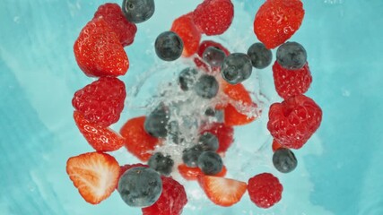 Canvas Print - Super Slow Motion of Falling Berries into Water, Blue Background. Filmed on High Speed Cinema Camera, 1000 fps. Camera Tracking the Target.