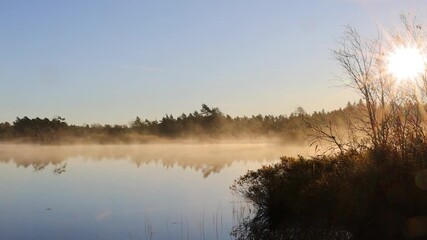 Wall Mural - Misty lake with sunbeams in a early autumn light