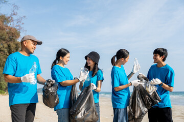 Group teamwork volunteer pick up the plastic bottle on the beach. People male and female Volunteer with garbage bags clean the trash on the beach make the sea beautiful. World environment day CSR.