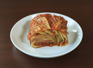 Wall Mural - Close-up of napa cabbage kimchi after Gimjang(kimchi-making) on a white dish and dark floor, South Korea
