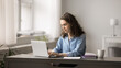 © fizkes - Attractive young woman working on studying on-line on laptop, sit at desk at home office, lead correspondence to client, e-mailing, solve business, e-learning using modern wireless device and internet