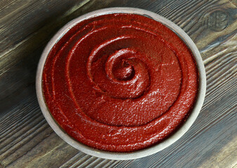 Poster - Close-up and top angle view of red pepper paste on a jar and wood floor, South Korea
