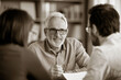 © Piyapat - Senior advisor meeting with a couple in a professional consultation setting, discussing documents in a modern office.