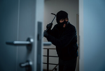 Wall Mural - Thief in uniform black jacket various action housebreak. The Robber terrorism criminal escapes with balaclava and crowbar entering a house for stealing Housebreak at night