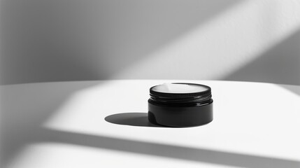 Canvas Print - Black cosmetic jar with white cream casting shadow on white table with harsh shadows