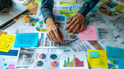 Leinwandbilder - A business analyst conducting market research with charts, graphs, and reports spread out on a conference table.