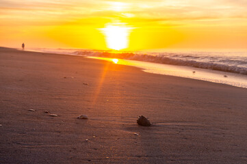 Sunrise on Beach with One Person Walking in Distance