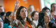 © Aigo labs - hispanic woman raises her hand in a conference setting, ready to ask a question or contribute to the discussion.