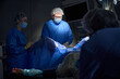 © Svitlana - Female and male surgeons operating on patient in operating theatre, using laparoscopic equipment