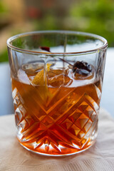 Wall Mural - A glass of whiskey with a cherry on top and an orange slice inside. The drink is a traditional old fashioned manhattan.