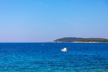 Wall Mural - Beautiful seascape with blue sea and white boat in Croatia. Boat is floating in the sea with a yellow buoy in the water. The sky is clear and blue, and the water is calm