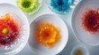© Zhanna - Overhead view of an artistic food presentation featuring colorful splashes on white plates. The abstract arrangement creates a visually stunning effect, suitable for themes of modern cuisine, food