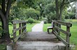© Cetin - narrow rubber walkway bridge with steel frames and wooden planks over the path in the park