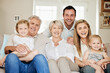 © Fanti/peopleimages.com - Portrait, parents or grandparents with children on sofa in home with bonding, embrace or relax with love in living room. Women, men or affection on couch in lounge for weekend visit, excited or care