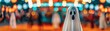 © Nattanon - Blurred night fair with bokeh lights, highlighted by a central ghost costume, reflecting a spooky Halloween atmosphere.