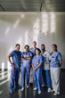 © Maskot - Portrait of male and female medical professionals standing together in front of wall at hospital