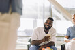 © Maskot - Happy male doctor laughing while holding disposable cup in hospital cafeteria