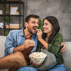 Wall Mural - adult couple watch movie, series on television and eat popcorn at home