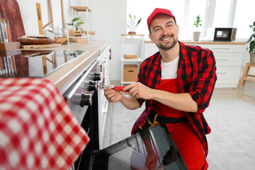 Sticker - Male technician with screwdriver repairing oven in kitchen