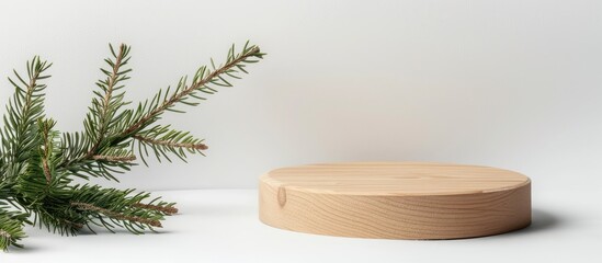 Poster - Mock up a wooden podium next to a spruce branch on a white backdrop ideal for eco friendly face and body care products with a copy space image available