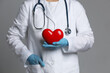 © New Africa - Doctor with red heart on grey background, closeup