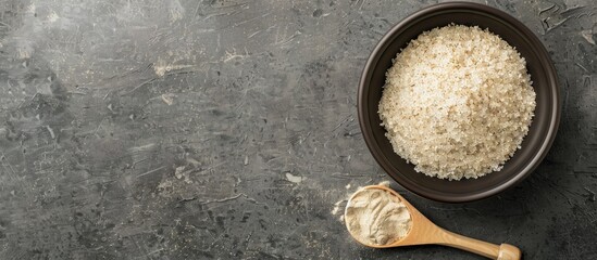 Psyllium husk powder in a bowl and scoop on a grey table seen from above with available space for text in the image. with copy space image. Place for adding text or design