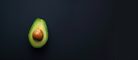 Aufkleber - Half an avocado on a black table with a copy space image for a healthy food concept