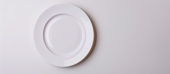 Poster - Top view of an unblemished plate on a white backdrop with copy space image