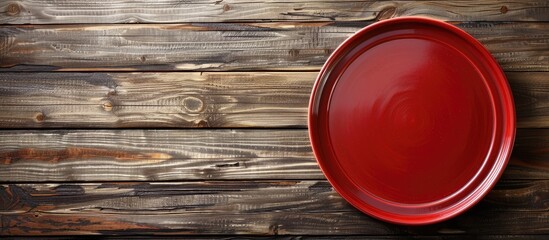 Poster - View of a red plate on wood background with copy space image for design