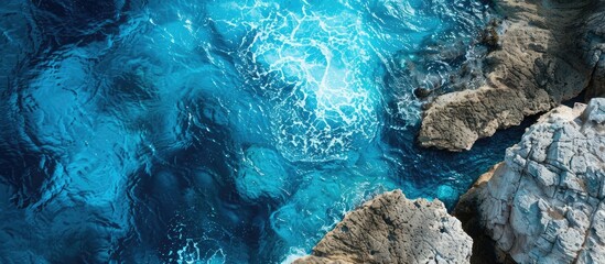 Poster - Aerial view of the ocean and stone with a scenic seascape as the backdrop showcasing various tones of turquoise copy space image