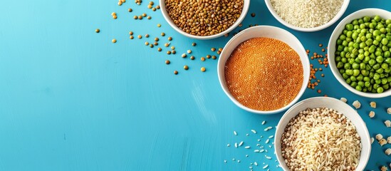 Leinwandbilder - Various cereals like buckwheat lentils rice and peas presented on plates with a blue background in a top view shot creating a composition with room for additional elements copy space image