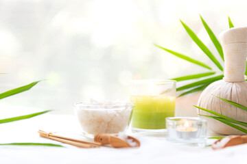 Wall Mural - Thai Spa Treatments aroma therapy salt and  sugar scrub massage with bamboo leaves with candle, white background. Thailand. Healthy Concept