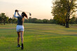 © freebird7977 - Golfer women sport course golf ball fairway. People lifestyle woman playing game golf swing tee of on the green grass sunset background. Asian female player game shot in summer